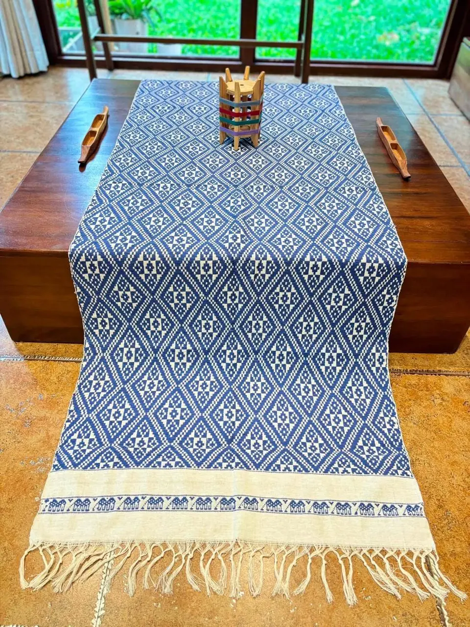 Handgewebter Läufer mit durchgehendem Rautengitter in Blau und Naturweiss auf einem Holztisch
